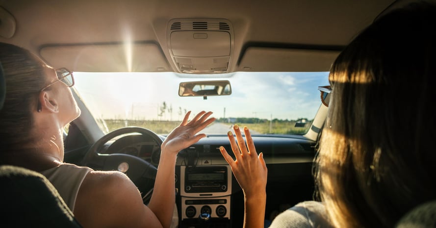 Two women listening to car radio