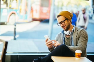 How Broadcast Media Drives Consumer Engagement - Man Texting in a Coffee Shop