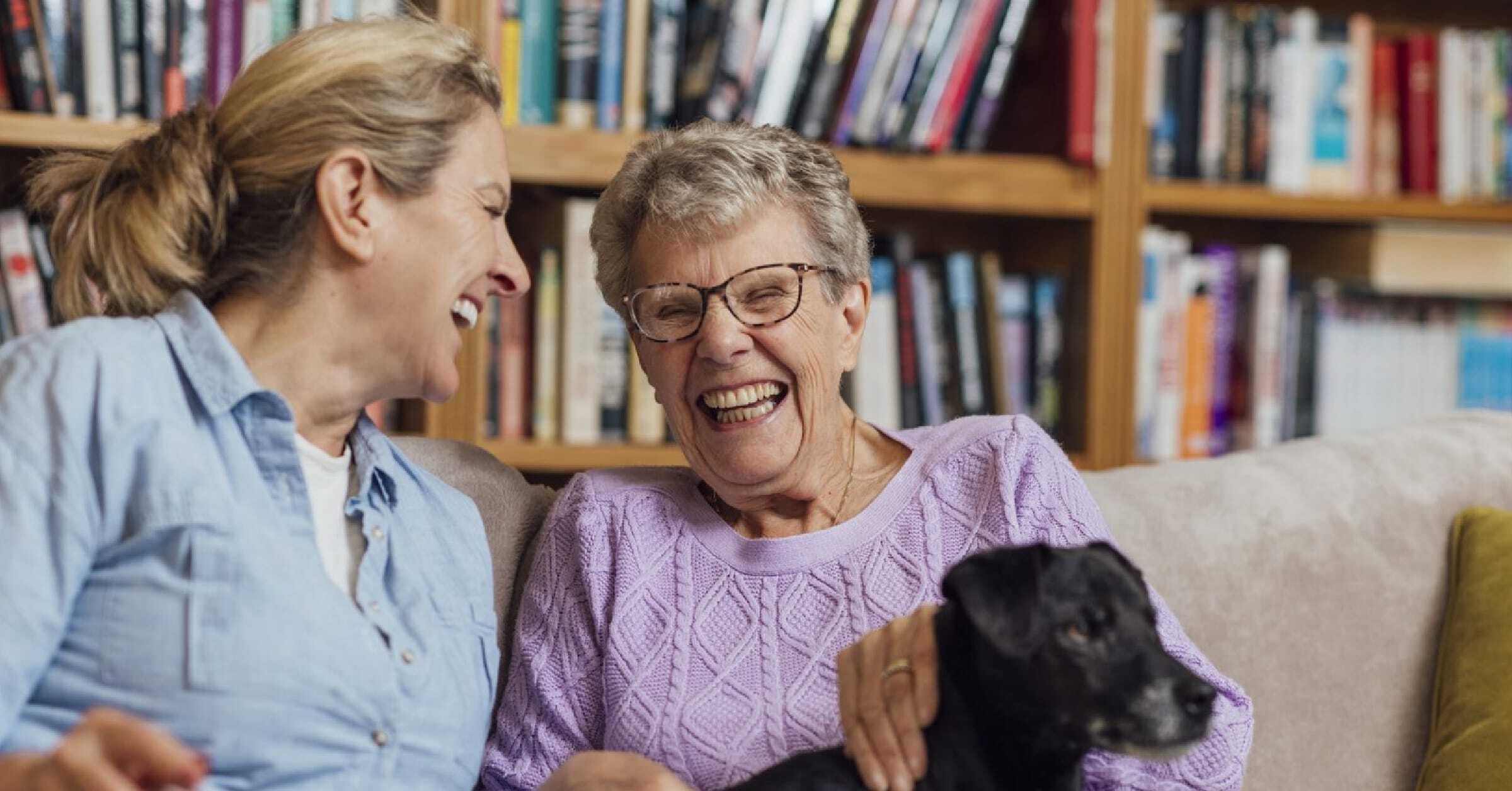 laughing-women-in-library-with-dog-on-lap